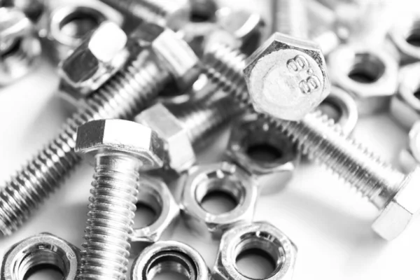 Metal bolts in a row background. Chromed screw bolts isolated. Steel bolts pattern. Set of Nuts and bolts. Tools for work. Black nd white — Stock Photo, Image