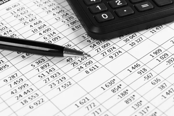 Financial concept. Calculator, pen and glasses on financial documents. Financial accounting. Balance sheets. Closeup of financial statements and annual reports. Business marketing