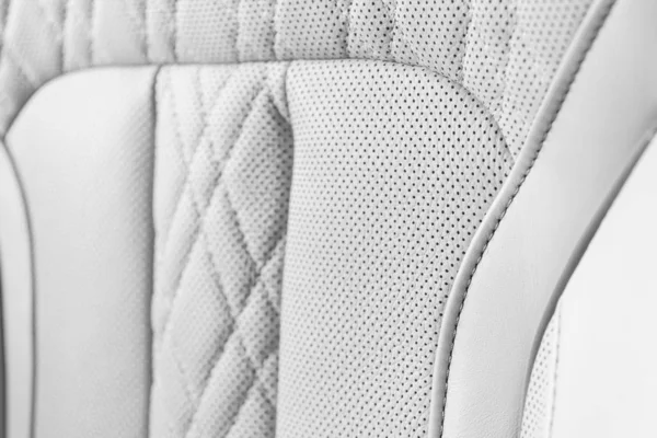 Moderno coche de lujo interior de cuero blanco. Parte de los detalles de asiento de coche de cuero perforado. Fondo de textura de cuero perforado blanco. Textura, cuero artificial con costuras. Asientos de cuero perforado — Foto de Stock