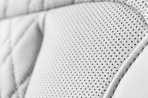 Modernes Luxusauto Innenraum aus weißem Leder. Teil perforierter Autositze aus Leder. weißen perforierten Leder Textur Hintergrund. Textur, Kunstleder mit Nähten. Lochledersitze — Stockfoto