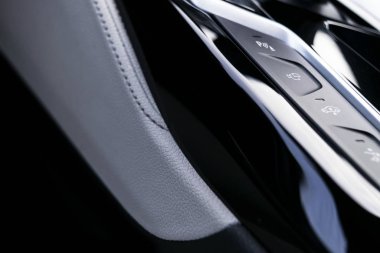 Modern bir arabanın beyaz deri kaplamalı, otomatik vites koluna yakın pist kontrol düğmeleri. Arabanın iç detayları. Araba içeride..