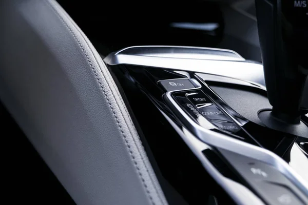 Botones de control de la pista cerca de la palanca de cambios automática en un interior de cuero blanco de un coche moderno. Detalles interiores del coche. Coche dentro . — Foto de Stock