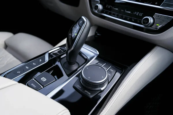 Botones de control de la pista cerca de la palanca de cambios automática en un interior de cuero blanco de un coche moderno. Detalles interiores del coche. Coche dentro . — Foto de Stock