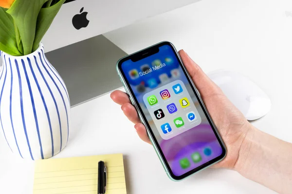 Apple iPhone 11 in woman hands with icons of social media facebook, instagram, twitter, snapchat application on screen. Social media icons. Social network — 스톡 사진