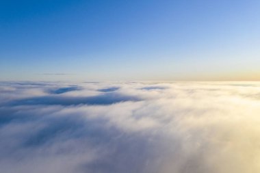 Mavi gökyüzünde havadan görünümü beyaz bulutlar. Üstten görünüm. Drone görüntüleyin. Hava kuş bakışı. Hava üstten görünüm cennet. Bulutlar doku. Yukarıdan görüntüleyin. Gündoğumu veya günbatımı bulutlar üzerinde