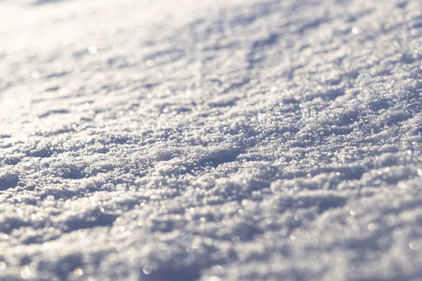 新的白雪特写的背景。冬天的雪花变得质感了.雪白质感的冬季背景是新鲜冰冷的冰.冰表面的图案。背景模糊，背景模糊的新雪 — 图库照片