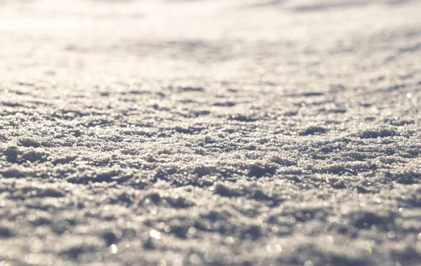 Pozadí čerstvě bílého sněhu detailní. Struktura zimních sněhových vloček. Sněhobílá textura zimní pozadí čerstvého studeného ledu. Vzor ledového povrchu. Lesklý sníh s bokeh a rozmazané pozadí — Stock fotografie