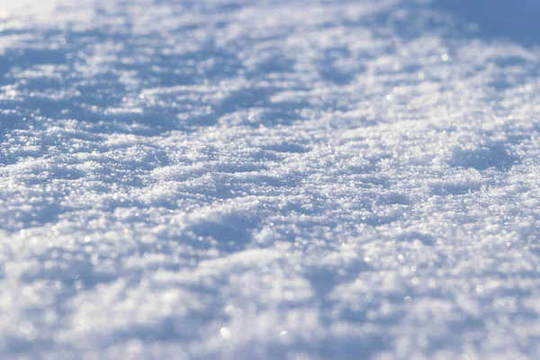 新的白雪特写的背景。冬天的雪花变得质感了.雪白质感的冬季背景是新鲜冰冷的冰.冰表面的图案。背景模糊，背景模糊的新雪 — 图库照片