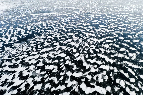 Vista aérea de una superficie congelada del lago. Patrón de nieve aérea en el lago congelado. Hielo congelado del lago capturado con un dron. Fotografía aérea. Textura nieve invierno — Foto de Stock