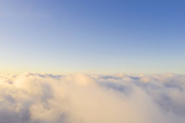 Mavi gökyüzünde beyaz bulutlar. Çok iyi. İHA 'dan bakıyorum. Havadan kuş bakışı. Üst hava manzarası bulutlu. Bulutların dokusu. Yukarıdan bak. Bulutların üstünde gün doğumu veya gün batımı