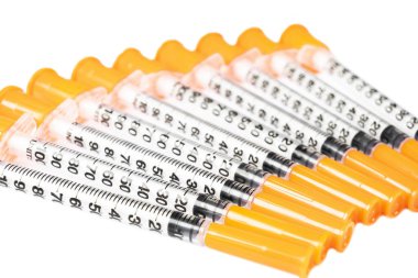 Beyaz arka planda izole edilmiş diyabet için insülin şırıngası yığını. Yakın çekim boş şırınga bir çiğ içinde izole. Plastik insülin şırıngası. Enjeksiyon ilacı. Tıbbi ekipman. Sağlık hizmeti kavramı