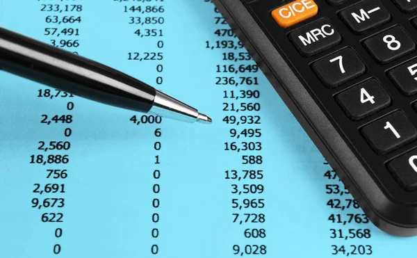 Financial concept. Calculator, pen and glasses on financial documents. Financial accounting. Balance sheets. Closeup of financial statements and annual reports. Business marketing