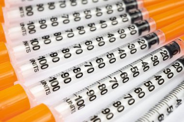 Beyaz arka planda izole edilmiş diyabet için insülin şırıngası yığını. Yakın çekim boş şırınga bir çiğ içinde izole. Plastik insülin şırıngası. Enjeksiyon ilacı. Tıbbi ekipman. Sağlık hizmeti kavramı