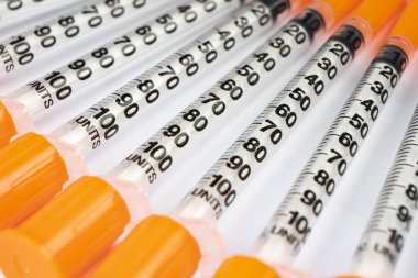 Beyaz arka planda izole edilmiş diyabet için insülin şırıngası yığını. Yakın çekim boş şırınga bir çiğ içinde izole. Plastik insülin şırıngası. Enjeksiyon ilacı. Tıbbi ekipman. Sağlık hizmeti kavramı