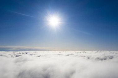 Mavi gökyüzünde hava manzaralı beyaz bulutlar. İnsansız hava aracı görüntüsü. Üst hava manzarası bulutlu. Bulutların dokusu. Yukarıdan bak. Bulutların üstünde gün doğumu ya da gün batımı. Panorama bulutları