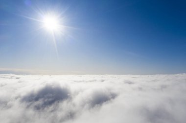 Mavi gökyüzünde hava manzaralı beyaz bulutlar. İnsansız hava aracı görüntüsü. Üst hava manzarası bulutlu. Bulutların dokusu. Yukarıdan bak. Bulutların üstünde gün doğumu ya da gün batımı. Panorama bulutları