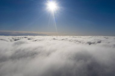 Mavi gökyüzünde hava manzaralı beyaz bulutlar. İnsansız hava aracı görüntüsü. Üst hava manzarası bulutlu. Bulutların dokusu. Yukarıdan bak. Bulutların üstünde gün doğumu ya da gün batımı. Panorama bulutları