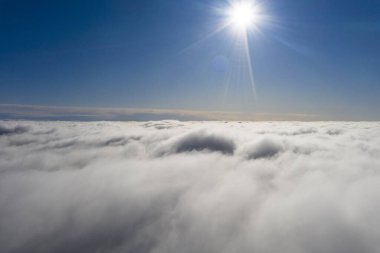 Mavi gökyüzünde hava manzaralı beyaz bulutlar. İnsansız hava aracı görüntüsü. Üst hava manzarası bulutlu. Bulutların dokusu. Yukarıdan bak. Bulutların üstünde gün doğumu ya da gün batımı. Panorama bulutları