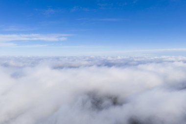 Mavi gökyüzünde hava manzaralı beyaz bulutlar. İnsansız hava aracı görüntüsü. Üst hava manzarası bulutlu. Bulutların dokusu. Yukarıdan bak. Bulutların üstünde gün doğumu ya da gün batımı. Panorama bulutları