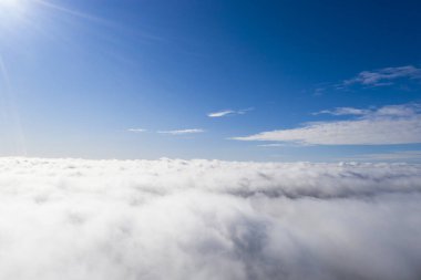 Mavi gökyüzünde hava manzaralı beyaz bulutlar. İnsansız hava aracı görüntüsü. Üst hava manzarası bulutlu. Bulutların dokusu. Yukarıdan bak. Bulutların üstünde gün doğumu ya da gün batımı. Panorama bulutları