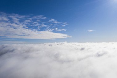 Mavi gökyüzünde hava manzaralı beyaz bulutlar. İnsansız hava aracı görüntüsü. Üst hava manzarası bulutlu. Bulutların dokusu. Yukarıdan bak. Bulutların üstünde gün doğumu ya da gün batımı. Panorama bulutları