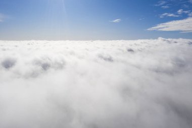 Mavi gökyüzünde hava manzaralı beyaz bulutlar. İnsansız hava aracı görüntüsü. Üst hava manzarası bulutlu. Bulutların dokusu. Yukarıdan bak. Bulutların üstünde gün doğumu ya da gün batımı. Panorama bulutları