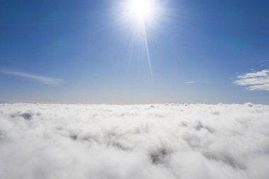 Mavi gökyüzünde hava manzaralı beyaz bulutlar. İnsansız hava aracı görüntüsü. Üst hava manzarası bulutlu. Bulutların dokusu. Yukarıdan bak. Bulutların üstünde gün doğumu ya da gün batımı. Panorama bulutları