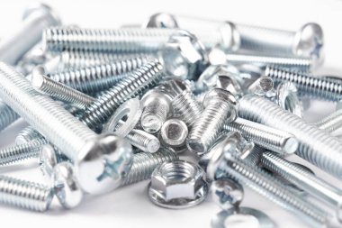 Bir satır arka planda metal cıvata ve somunlar. Krom vida cıvata ve somun izole. Çelik cıvata ve somun deseni. Somun ve cıvata seti. İş için araçlar.