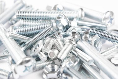 Bir satır arka planda metal cıvata ve somunlar. Krom vida cıvata ve somun izole. Çelik cıvata ve somun deseni. Somun ve cıvata seti. İş için araçlar.