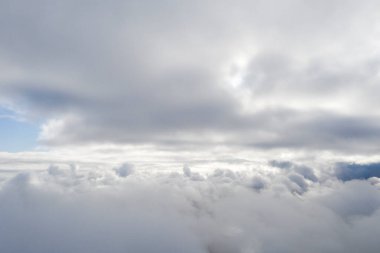 Mavi gökyüzünde hava manzaralı beyaz bulutlar. İnsansız hava aracı görüntüsü. Üst hava manzarası bulutlu. Bulutların dokusu. Yukarıdan bak. Bulutların üstünde gün doğumu ya da gün batımı. Panorama bulutları