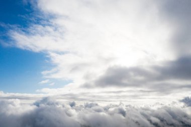 Mavi gökyüzünde hava manzaralı beyaz bulutlar. İnsansız hava aracı görüntüsü. Üst hava manzarası bulutlu. Bulutların dokusu. Yukarıdan bak. Bulutların üstünde gün doğumu ya da gün batımı. Panorama bulutları