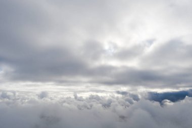 Mavi gökyüzünde hava manzaralı beyaz bulutlar. İnsansız hava aracı görüntüsü. Üst hava manzarası bulutlu. Bulutların dokusu. Yukarıdan bak. Bulutların üstünde gün doğumu ya da gün batımı. Panorama bulutları