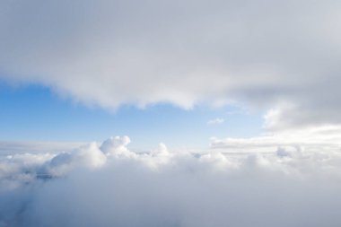 Mavi gökyüzünde hava manzaralı beyaz bulutlar. İnsansız hava aracı görüntüsü. Üst hava manzarası bulutlu. Bulutların dokusu. Yukarıdan bak. Bulutların üstünde gün doğumu ya da gün batımı. Panorama bulutları