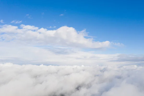 Aerial view white clouds in blue sky. View from drone. Aerial top view cloudscape. Texture of clouds. View from above. Sunrise or sunset over clouds. Panorama clouds