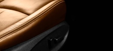 Lüks modern arabanın içi kahverengi deri. Siyah arka planda dikişli delinmiş kahverengi deri koltuklar. Modern araba iç dekorasyonu. Araba tamiri. Araba içeride.