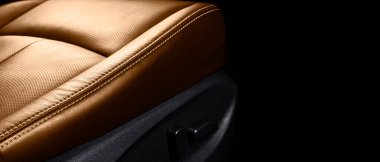 Lüks modern arabanın içi kahverengi deri. Siyah arka planda dikişli delinmiş kahverengi deri koltuklar. Modern araba iç dekorasyonu. Araba tamiri. Araba içeride.