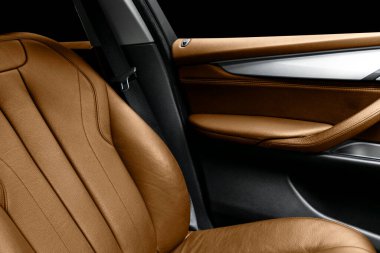 Lüks modern arabanın içi kahverengi deri. Siyah arka planda dikişli delinmiş kahverengi deri koltuklar. Modern araba iç dekorasyonu. Araba tamiri. Araba içeride.