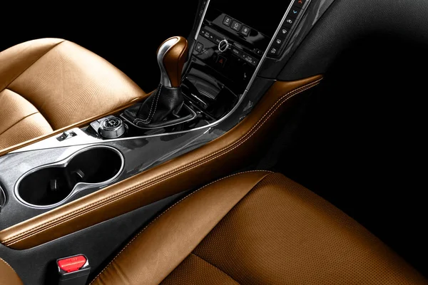 Brown leather interior of the luxury modern car. Perforated brown leather comfortable seats with stitching isolated on black background. Modern car interior details. Car detailing. Car inside