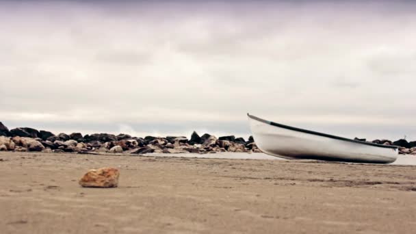 Лодка на берегу с разбивающимися волнами на заднем плане — стоковое видео
