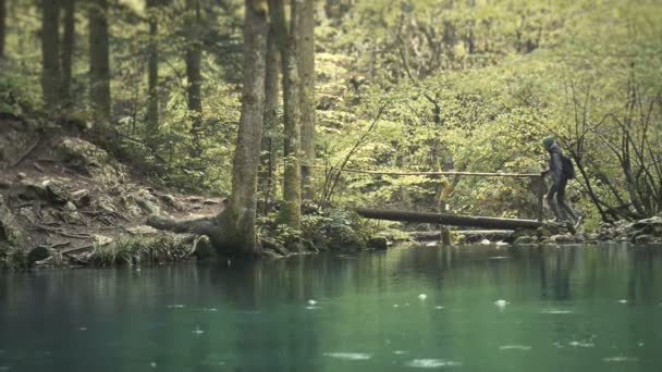 Wanderinnen gehen in Zeitlupe auf Holzbrücke. schöner blauer See — Stockvideo