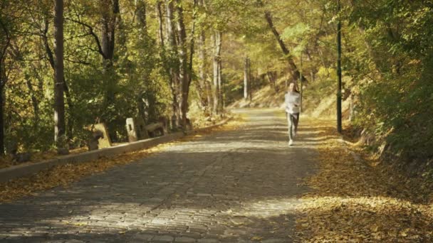 Correr mirando el reloj inteligente del monitor de frecuencia cardíaca mientras se ejecuta. Corredor de mujeres corriendo afuera mirando deportes reloj inteligente durante el entrenamiento para correr maratón . — Vídeos de Stock