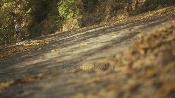 Gros plan des pieds d'un coureur, courant dans les feuilles d'automne. Exercice d'entraînement — Video