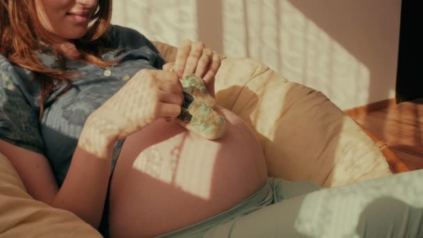 Маленькая обувь для нерожденного ребенка на животе беременных женщин — стоковое видео