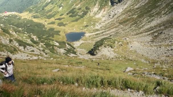 Pěší turistika mladá žena s horami a alpské jezero na pozadí. Šplhání do kopce — Stock video