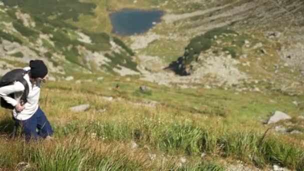 Hiking young woman with mountains and alpine lake on background. Close up shot — Stock Video