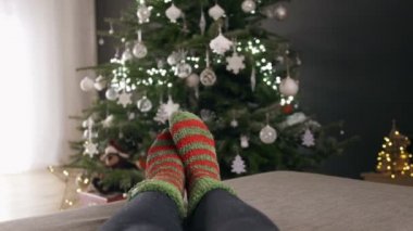 Kadın Noel ağacı tarafından çoraplı ayak Noel ağacı ve arka plan üzerinde bulanıklık