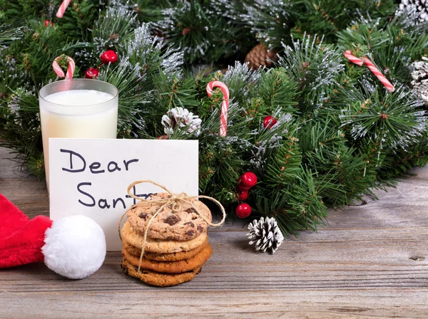 Cookies and milk plus card for Santa Claus with holiday decorati — Stock Photo, Image