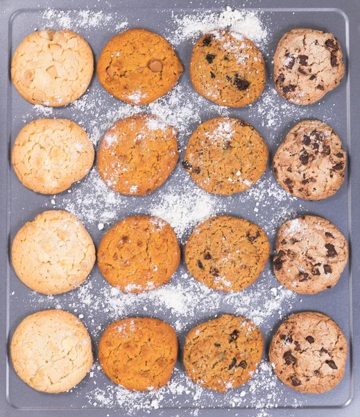 Variety of baked cookies with flour on baking sheet ready to eat — Stock Photo, Image