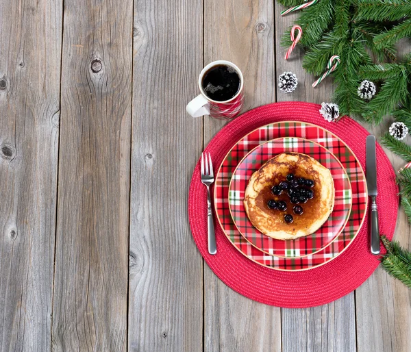 Christmas breakfast setting with evergreen branches on rustic wo — Stock Photo, Image