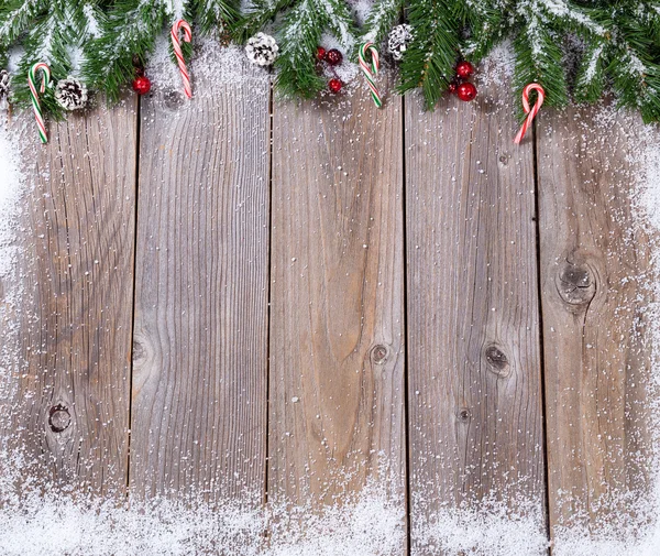 质朴的木板上，用雪覆盖冷杉为圣诞节 con 的枝条 — 图库照片